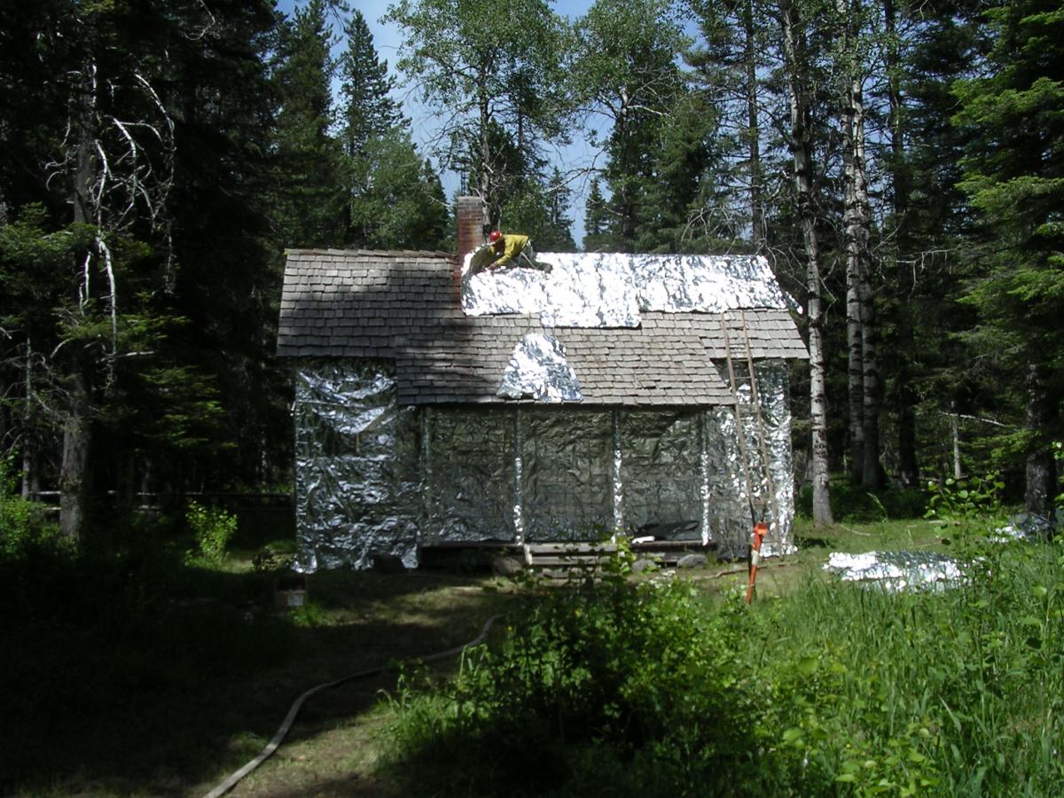 Gotchen Creek Ranger Station being wrapped for protection against forest fire.